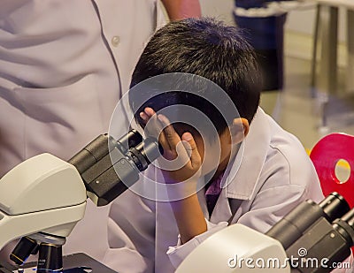 Asian boy looking through microscope Stock Photo