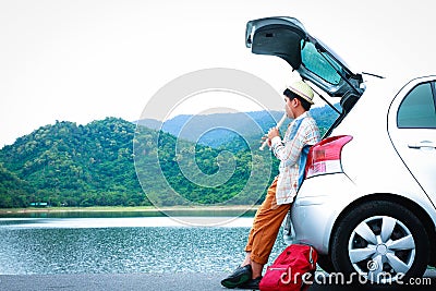 An Asian boy playing a flute in the back of a car, enjoying music Stock Photo