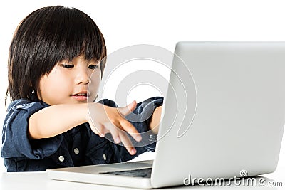 Asian boy playing on laptop. Stock Photo