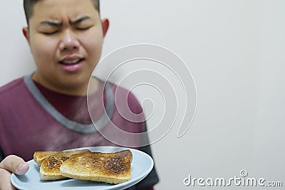 Asian boy show over roasted burnt grilled bread Stock Photo