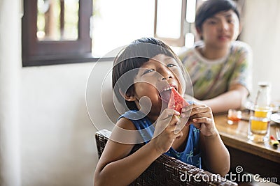 Asian boy snacking on a watermelon Stock Photo