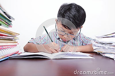Asian boy studying seriously on a desk and white background Stock Photo