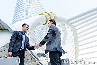 Two asian business have handshake with building and city background. Stock Photo