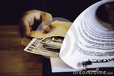 Asian business individual who owns the business sign personally sealing the deal with receiving a bribe money.The concept of Stock Photo