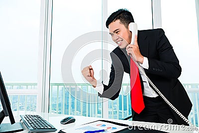 Asian business man telephoning in office Stock Photo