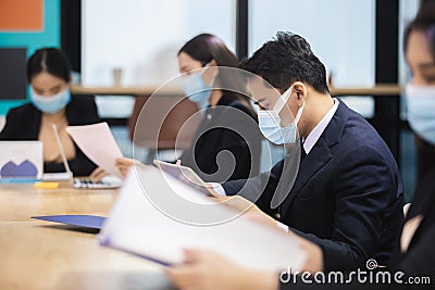 Asian business people wear masks protect against airborne disease during outbreak of covid-19 or coronavirus meeting conference. Stock Photo
