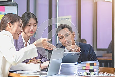 Asian business team consists of marketing staff. accountant and financial officer Help each other analyze company profits using Stock Photo