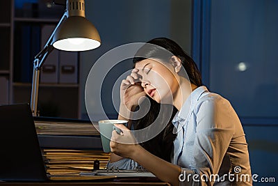 Asian business woman drink coffee refreshing working overtime la Stock Photo