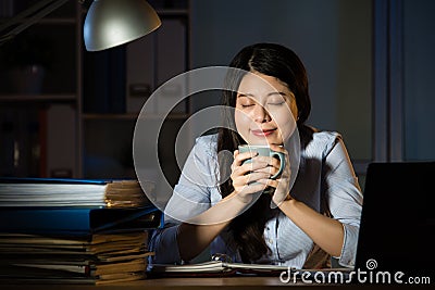 Asian business woman drink coffee working overtime late night Stock Photo