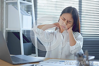 Asian business woman have a neck pain because using the laptop computer and working for a long time. Stock Photo