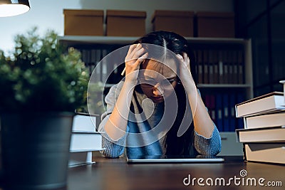 Asian business woman suffers from headache from working with computers for a long time. Stock Photo