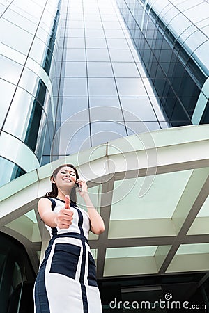 Asian business woman telephoning outside with phone Stock Photo