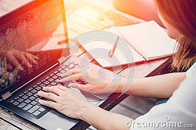 Asian Business woman work typing on laptop with graph data on screen Stock Photo