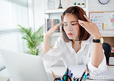 Asian business women have stress and headaches from their work at the office Stock Photo