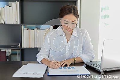 Asian Business women working and analysis graphics at office Stock Photo