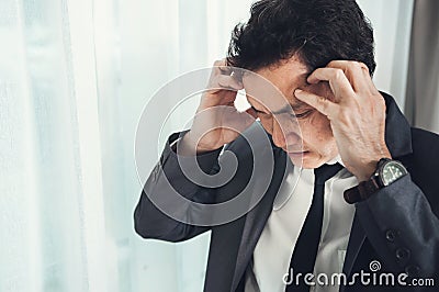 Asian businessman has headache from migraine from overworked. Il Stock Photo