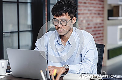 Asian businessman woking with laptop and paper work on desk at office.digital workflow online business lifestyle concept Stock Photo