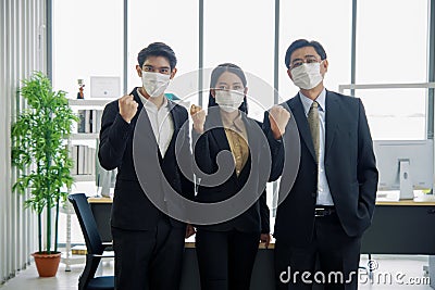 Asian businessmen and businesswoman are wearing mask at workplace to prevent the corona virus outbreak Stock Photo