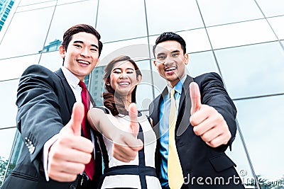 Asian businesspeople outside in front of skyscraper Stock Photo