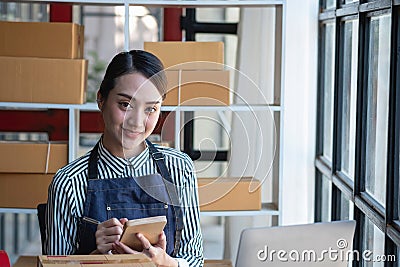 An Asian businesswoman enjoys his online SME business selling products, profiting from opening an online store, and taking orders Stock Photo