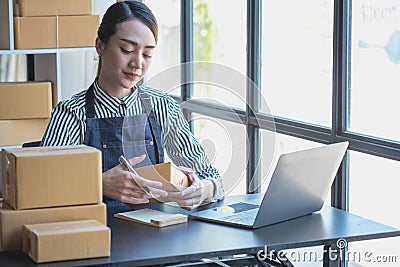 An Asian businesswoman enjoys his online SME business selling products, profiting from opening an online store, and taking orders Stock Photo