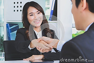 Asian businesswoman making handshake with a businessman Stock Photo