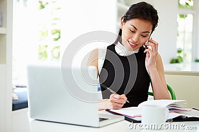 Asian Businesswoman Working From Home Using Mobile Phone Stock Photo