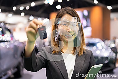 Asian car seller wearing face mask give car key to customer Stock Photo