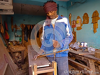 asian carpenter drilling on wooden furniture at workshop in india January 2020 Editorial Stock Photo