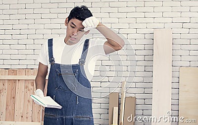 Asian carpenter getting tired after work Stock Photo