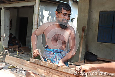 Asian carpenter working with wooden plane at a furniture workshop Editorial Stock Photo