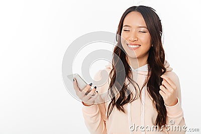 Asian cheerful woman listening music with headphones. Stock Photo