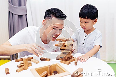Asian child and father playing with wooden blocks in the room at home. A kind of educational toys for preschool and kindergarten Stock Photo