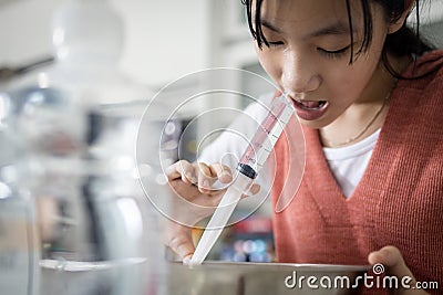 Asian child girl having stuffy nose,difficulty breathing,nasal wash,nose cleaning with syringe and saline,nasal sinus infection, Stock Photo