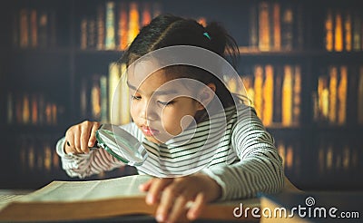 Asian child girl industrious is sitting at a desk indoors. Kid is learning in home Stock Photo