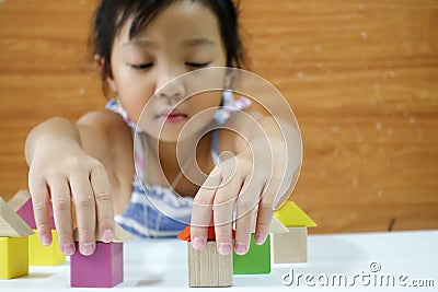 Asian child girl is playing wooden toys Stock Photo