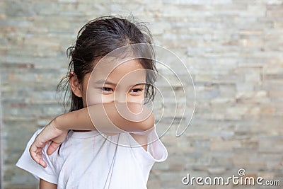 Asian child girl sneezing on hinge joints arm for protect from virus and stop coronavirus covid19 outbreak. Stock Photo