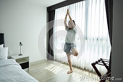 Asian child girl standing with her eyes closed and doing yoga vrikshasana pose,breathing exercise workout,practicing yoga in her Stock Photo