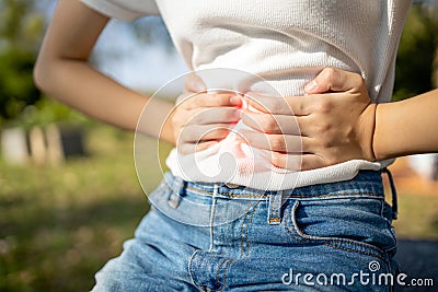 Asian child girl with stomach ache,woman having aching belly with stomach flu or gastroenteritis virus norovirus infection Stock Photo