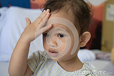 Asian child keeps a hand for a head Stock Photo