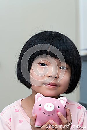 Asian child with piggy bank Stock Photo