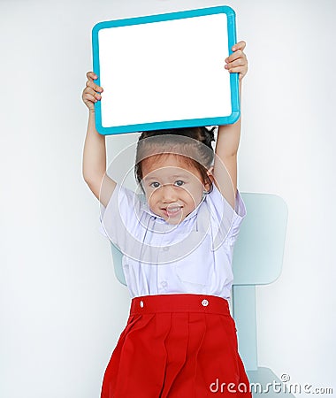 Asian child in school uniform holding empty whiteboard isolated on white background Stock Photo