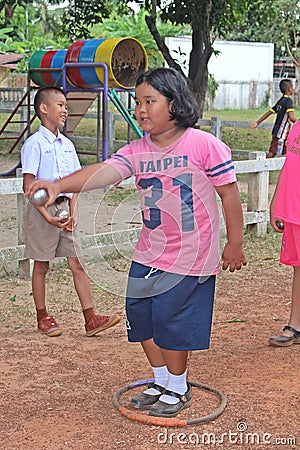 Asian child is throwing petanque ball. Editorial Stock Photo