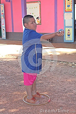 Asian child is throwing petanque ball. Editorial Stock Photo