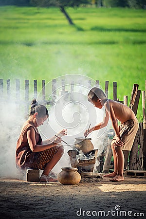 Asian children boy and girl are cooking in the Kitchen of the Co Stock Photo