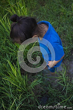 Asian children play jumping in the muddy puddle at rice field Stock Photo