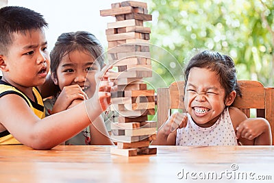 Asian children playing wood blocks stack game together with fun Stock Photo