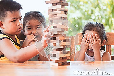 Asian children playing wood blocks stack game together with fun Stock Photo