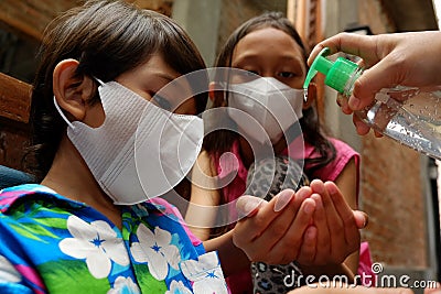 Asian children using liquid gel hand sanitizer Stock Photo