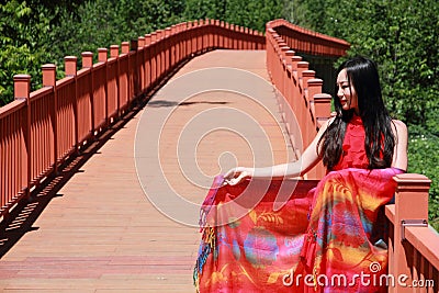 Asian Chinese beauty in red dress enjoy peaceful and happy life at Yunnan Lugu walking marriage bridge Stock Photo